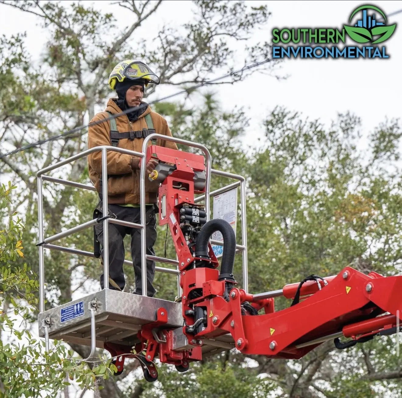 Certified arborist trimming tree canopy near power lines using compact spider lift
